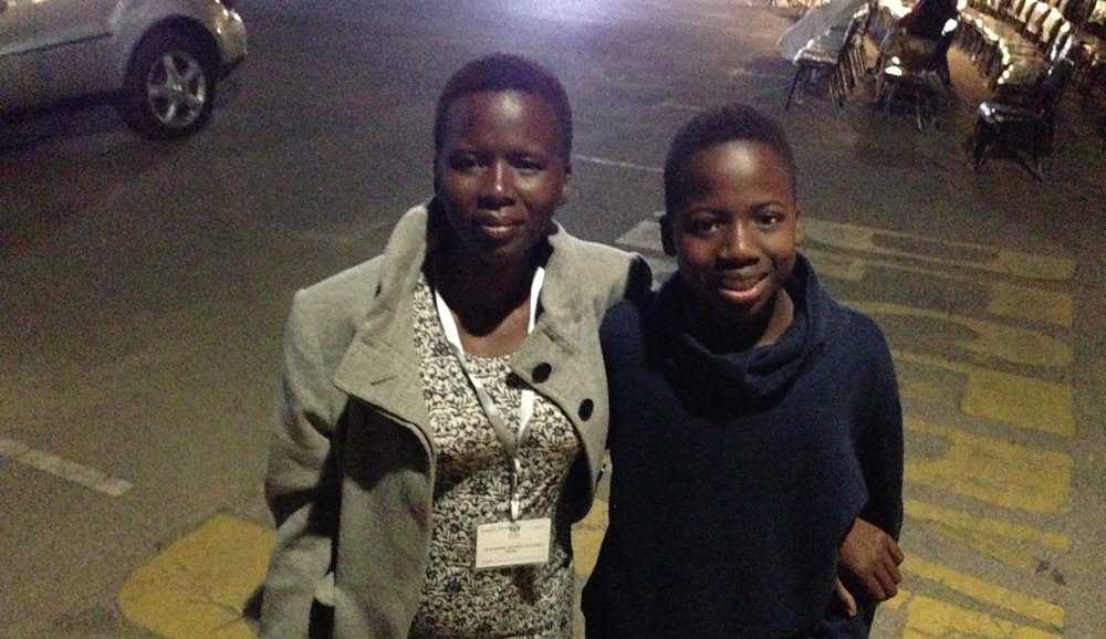 Linda Sibanda posing with her 14-year-old son, Vusi, in the parking lot after an evangelistic series in Chitungwiza, Zimbabwe, on Wednesday, May 27. (Andrew McChesney / AR)