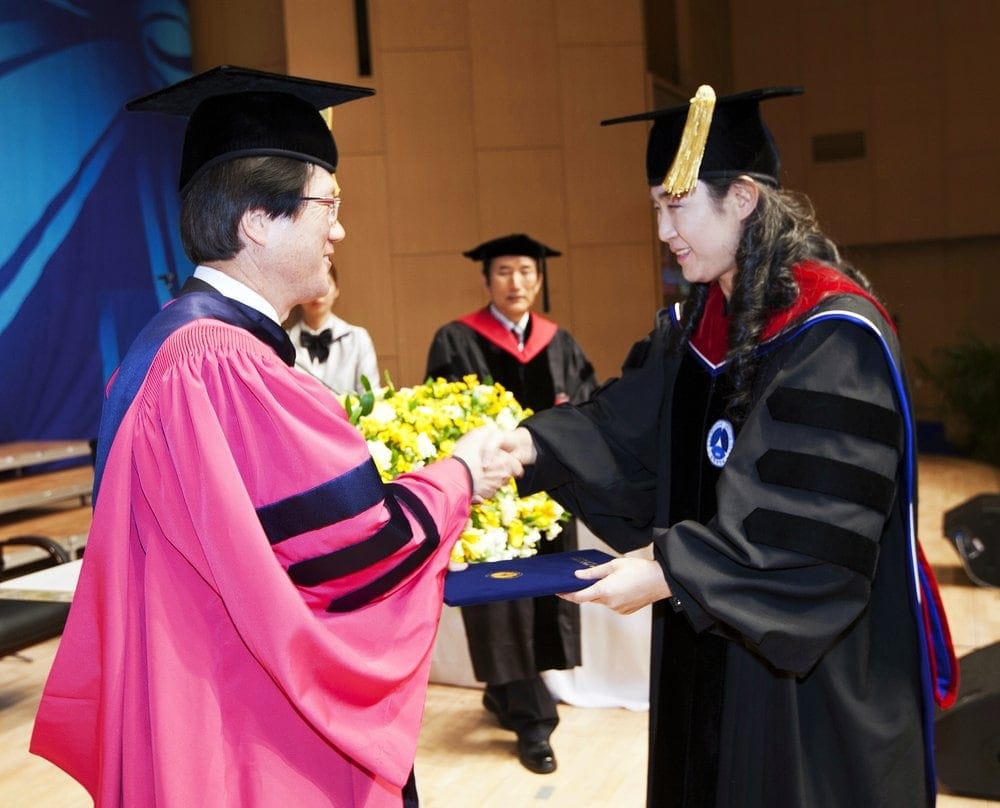 Kim Sang Rae. president of Sahmyook University, presenting Miriam Yun-Welch with a doctorate in ministry diploma as Jong-Keun Lee, dean of the school of theology, watches. Photo courtesy of Jong-Keun Lee