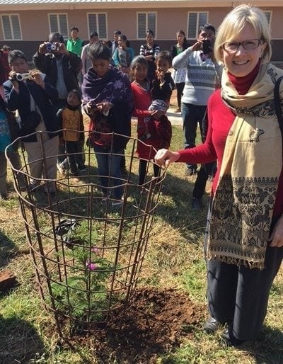 Nancy Wilson planting a tree at the opening of a new library at Northeast Adventist College.