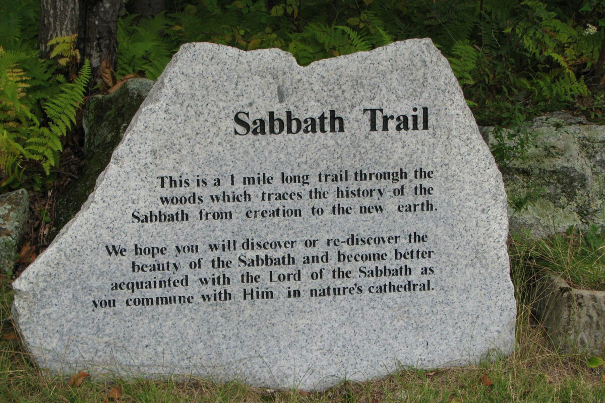 Granite trailhead marker for the Sabbath Trail, describing a one-mile walk through the woods recounting the history and meaning of the Sabbath.
