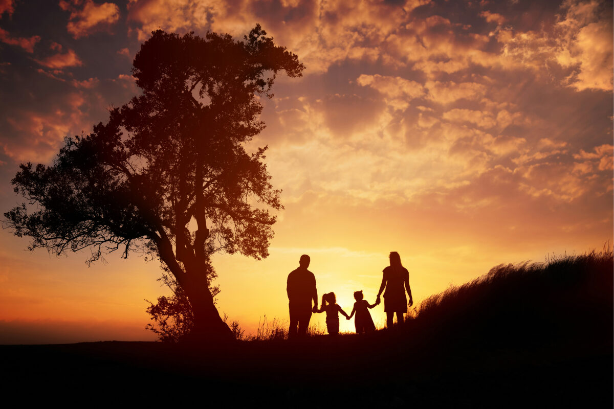 A family of four watch the sunset.