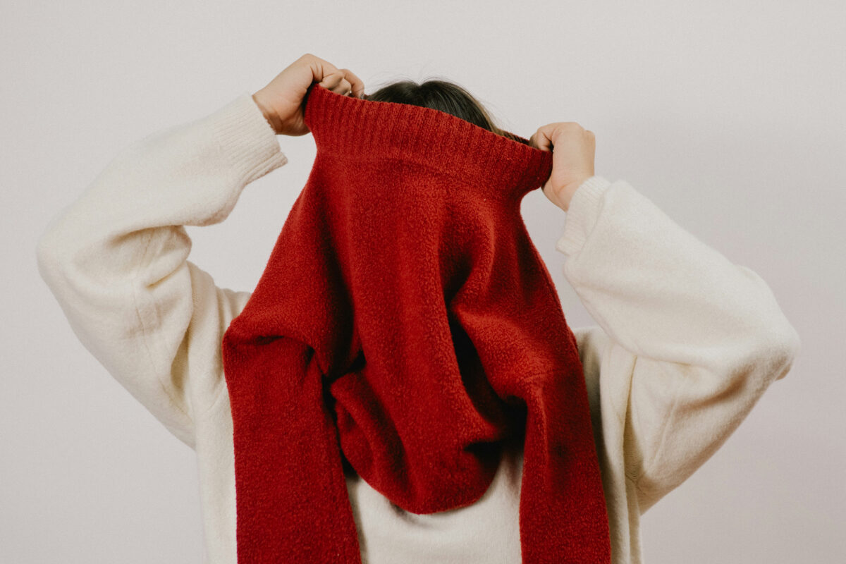 Person putting on layers of clothing.