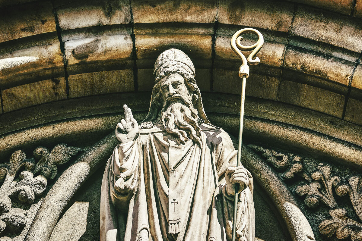 A stone statue of Saint Patrick holding a staff stands in an ornate architectural niche in the church in Belfast's City Centre