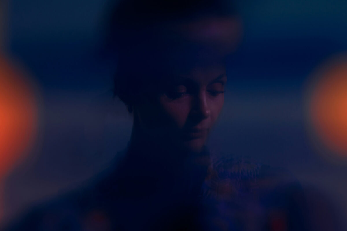 A photo of a contemplative figure illuminated by subtle, moody lighting, creating a calm and introspective atmosphere.